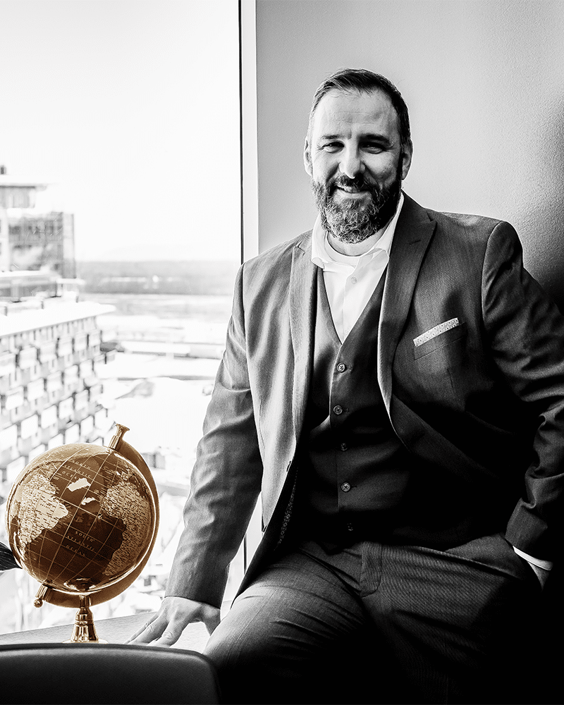 Denis Bourque, fondateur de Planico, assis près d'une fenêtre avec un globe doré.