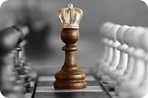 Pion d'échecs avec une couronne, représentant la planification de la succession.